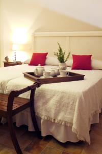 a large bed with a tray with bowls on it at Casa Rural Alcancia in Consuegra