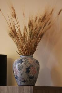 un vase bleu et blanc avec un peu d'herbe haute dans l'établissement Casa P&G, à Niscemi