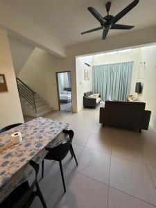 a living room with a table and a ceiling fan at AYAAN PENTHOUSE at Golden Hill Night Market View in Brinchang
