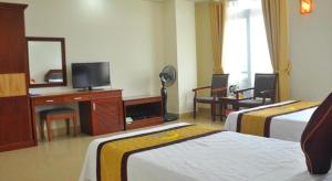 una camera d'albergo con due letti e una televisione di Hai Long Hotel Cat Ba a Cat Ba