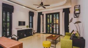 un soggiorno con divano verde e ventilatore a soffitto di Mulberry Hotel a Siem Reap