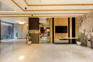 una hall con una televisione e piante in vaso di OPO VERTU Premium Delhi Aerocity a Nuova Delhi