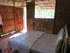 - une chambre avec un lit dans une cabane dans l'établissement My Hoa Mekong Homestay, à Vĩnh Long