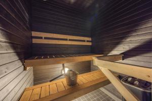 a sauna with a bench and a bucket in it at Holiday Apartment Skivillas 26 B 2 in Ukkohalla +10 photos