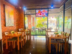 a restaurant with wooden tables and chairs in a room at Noble Boutique Hotel Chiang Mai By J&S Property in Chiang Mai