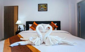 two swans made out of towels on a bed at Noble Boutique Hotel Chiang Mai By J&S Property in Chiang Mai