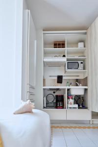 a living room with a couch and a microwave at Studio Sucre de Canne - Résidence calme avec plage et piscine privées in Saint-François +27 photos