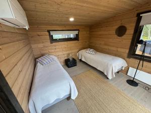 a room with two beds in a wooden cabin at Villa Terwaluoto in Oulu