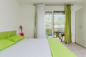 a bedroom with a bed and a balcony with a table at Dream Vacation Apartments in Tivat