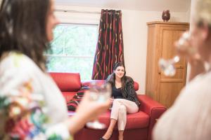 a woman sitting on a couch with a wine glass at Chester Apartments in Chester