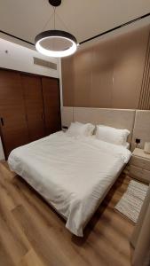 una camera con letto bianco e luce di Luxury 1BHK with Balcony - Muscat Hills a Mascate