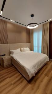 una camera da letto con un grande letto bianco e una luce di Luxury 1BHK with Balcony - Muscat Hills a Mascate