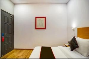 a bedroom with a bed and a picture on the wall at RROOMS Hotel La-Maison in Lucknow