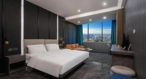 a bedroom with a large white bed and a living room at Haikou Kai Wei Hotel in Haikou +278 photos