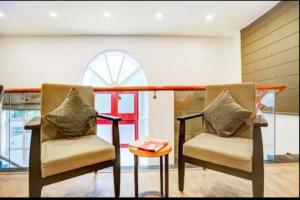 two chairs and a table in a room at RROOMS Hotel La-Maison in Lucknow