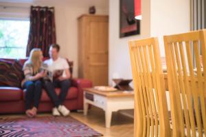 a man and a woman sitting on a couch at Chester Apartments in Chester