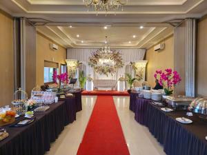 a large banquet hall with long tables with food at The Margangsa Hotel in Solo