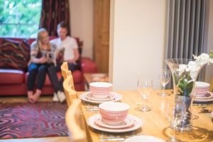 a table with plates and glasses and a man and a woman at Chester Apartments in Chester