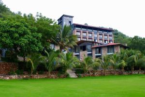 a building with palm trees in front of a yard at The Divine Hills Resort Suites with Private Pool Near IIM Udaipur in Nāi +147 photos