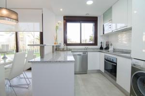 a kitchen with white cabinets and a counter top at Arenales Playa Superior by Mar Holidays in Arenales del Sol