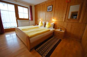 um quarto com uma cama num quarto com paredes de madeira em Gasthof La Pli Apartments em San Vigilio Di Marebbe