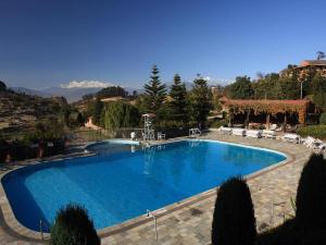 a large blue swimming pool in a house at Godavari Village Resort in Kathmandu