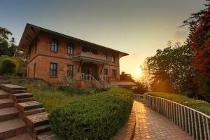 a brick house with a sunset in the background at Godavari Village Resort in Kathmandu