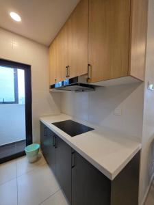 una cucina con mobili in legno e un piano di lavoro di Reizz Residence By Nexus Suites a Kuala Lumpur