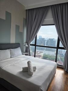 una camera da letto con un letto bianco e una grande finestra di Reizz Residence By Nexus Suites a Kuala Lumpur