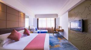 a hotel room with a large bed and a television at Downtown Hotel in Zhuhai