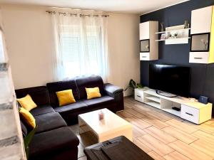 a living room with a couch and a tv at DaMa in Kaštela