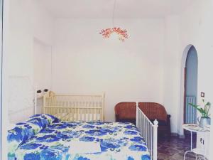 a bedroom with a bed with a blue and white comforter at B&B SanteBice in Polignano a Mare