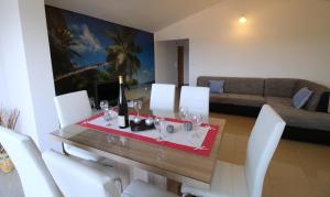 a dining room with a table and white chairs at Apartments Lucefinka in Banjole