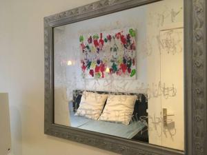 a mirror with a reflection of a bed in a room at Huswell Artsy Family Apartment in City Center in Antwerp +6 photos