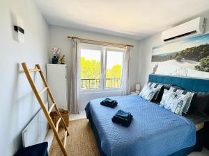 Un dormitorio con una cama azul y una ventana. en Amazing sea view apartment in Miraflores, en La Cala de Mijas 62 fotos más