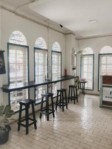 a large room with tables and stools and windows at Fafan Budget Hotel in Padang