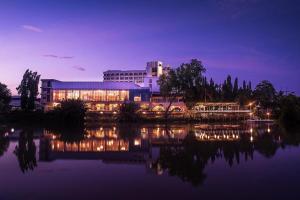 a building next to a body of water at night at Wangtai Hotel in Suratthani