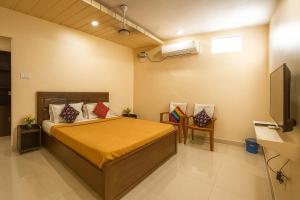 a bedroom with a bed and a flat screen tv at VJR Residency in Arcot
