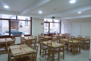 ブダペストにあるCenter Hostel and Guest Houseの木製のテーブルと椅子、窓のあるレストラン