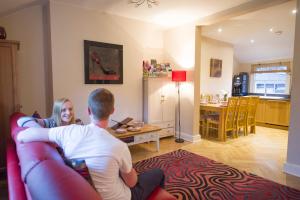 a man and woman sitting on a couch in a living room at Chester Apartments in Chester