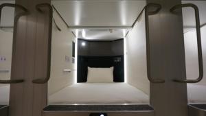 Mały pokój z łóżkiem z białą poduszką w obiekcie Akihabara Bay Hotel (Female Only) w Tokio