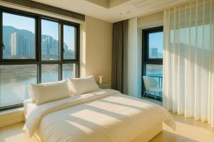 a bedroom with a large bed and large windows at EL Stay Hotel Residence in Busan +64 photos