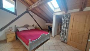 una camera da letto con un letto con un piumone rosso di Antico Fienile By Go new Location a Panchia