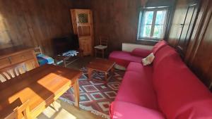 un soggiorno con un divano rosso e un tavolo di Antico Fienile By Go new Location a Panchia