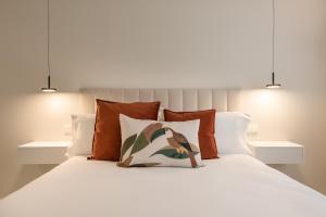 a bedroom with a white bed with orange pillows at Loft América 41 B in Melide