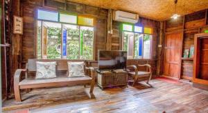 - un salon avec un banc, des chaises et des fenêtres dans l'établissement OYO 1155 Bikers House and Enduro Tours Chiang Mai, à Chiang Mai