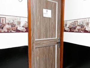 a wooden door with a sign on it in a room at Radom Residence in Jakarta