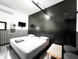 a bedroom with a white bed and a black wall at Radom Residence in Jakarta