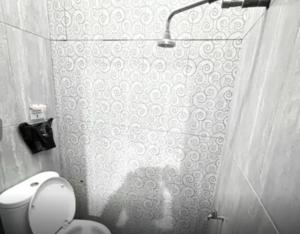 a bathroom with a toilet and a shower curtain at Radom Residence in Jakarta