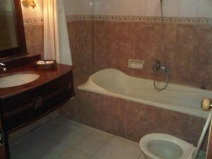 a bathroom with a tub and a toilet and a sink at Larisae Setia Kawan Hotel in Kadiporo +58 photos